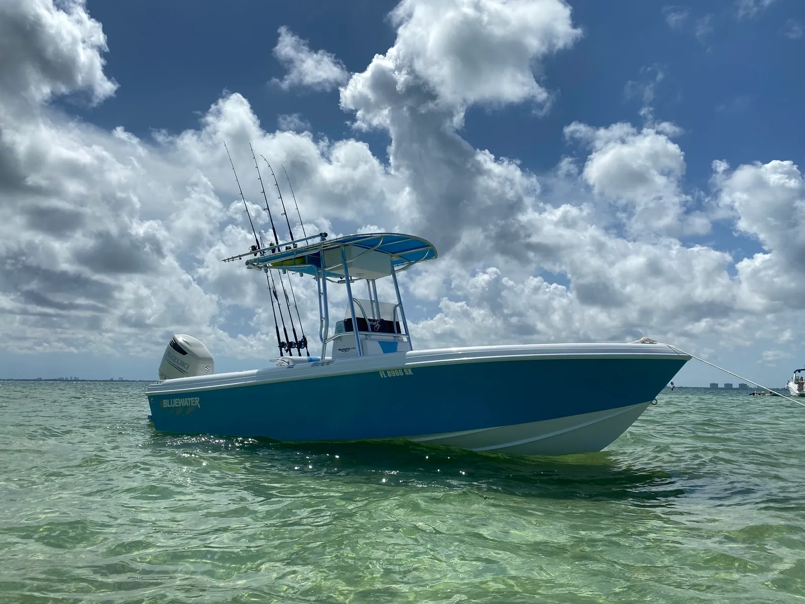 Blue-hulled Bluewater 2150 on the flats under a summer sky